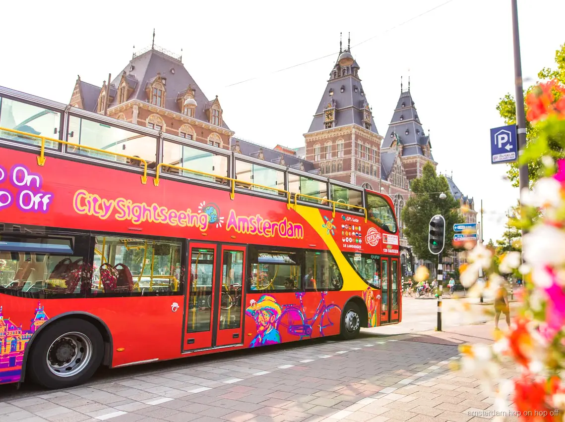 Amsterdam Hop-On Hop-Off Boot fährt durch den Grachtengürtel neben der Buslinie